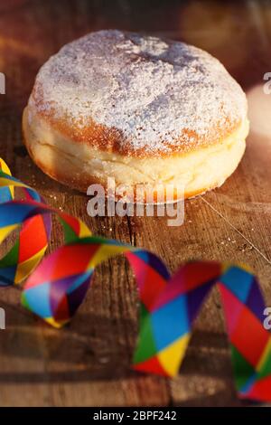 Donut avec décoration de carnaval colorée sur table en bois rustique verticale Banque D'Images