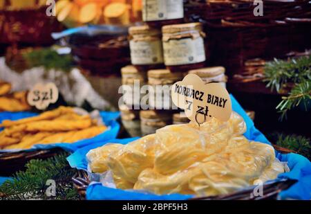 Gros plan du fromage fumé avec des étiquettes de prix et d'autres aliments sur une position sur le marché traditionnel de la Pologne. Banque D'Images