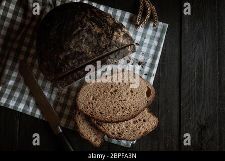 Des tranches de pain sur une table en bois rustique. Télévision jeter image avec du pain brun maison Banque D'Images