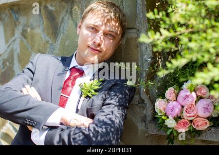 Magnifique groom avec un bouquet extérieur. Banque D'Images