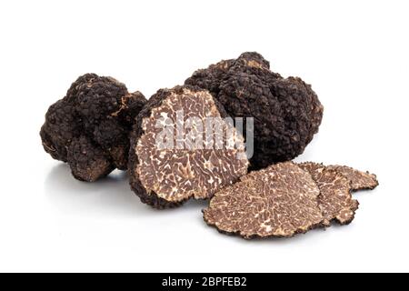 Libre tourné de truffes noires et feuilles de chêne isolé sur fond blanc. Banque D'Images