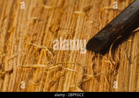 Les copeaux de bois et les couteaux se situent sur une planche en bois close-up. Banque D'Images