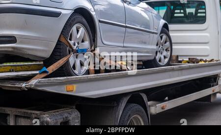 Véhicule cassé chargé sur un camion de remorquage. Voiture remorquée. Endommager le véhicule après un accident Banque D'Images