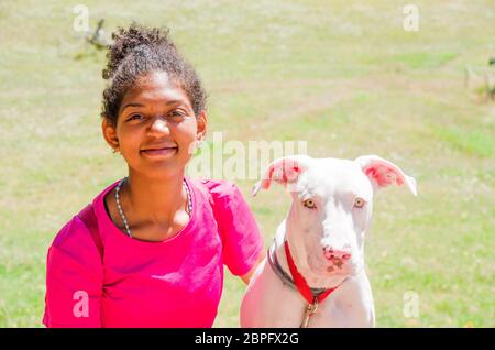 Jeune entraîneur brésilien de chien avec beau chien blanc avec de grands yeux jaunes Banque D'Images