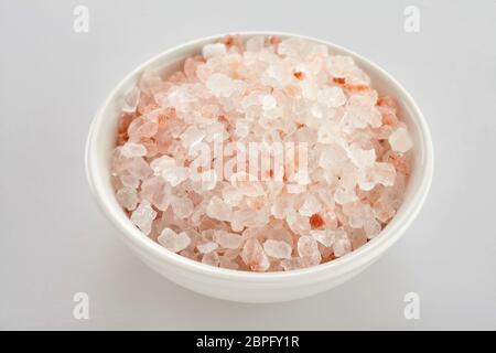 Bol de céréales secondaires, une rose sel de l'Himalaya de sel gemme ou halite utilisée pour l'assaisonnement de la nourriture, sur un fond blanc Banque D'Images