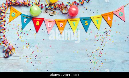 Geburtstag ou fête d'arrière-plan avec des banderoles et des ballons au-dessus d'une chaîne de texte coloré bunting avec l'allemand et l'espace ci-dessous copie sur bleu w Banque D'Images