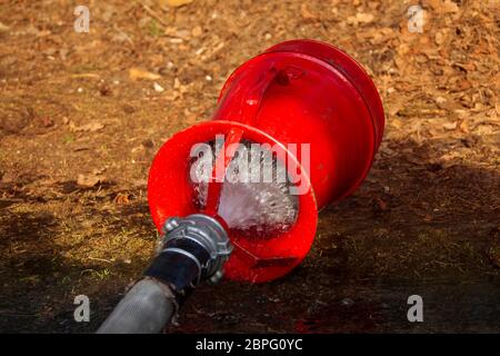 Tuyau d'incendie avec de l'eau sur le sol. Extinction d'incendie Banque D'Images