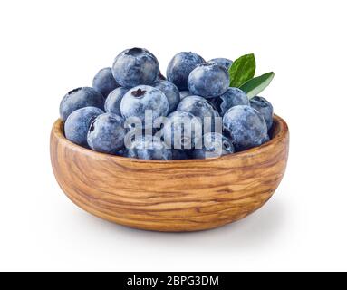 De magnifiques bleuets avec des feuilles de bleuets dans un bol en bois isolé sur fond blanc. Banque D'Images