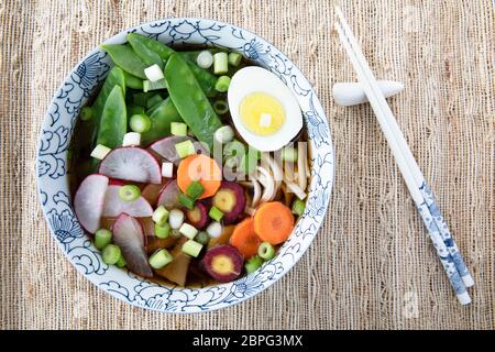 Bol de remplissage avec la soupe de nouilles Udon series image finale : bol avec des nouilles, des champignons shiitake, les pois, le bouillon, les radis, carottes, oeuf. et ressort oni Banque D'Images