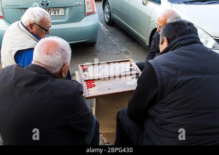 Des hommes s'assoient autour d'un backgammon en dehors du marché central de Telavi dans la région viticole de Kakheti, République de Géorgie. Banque D'Images