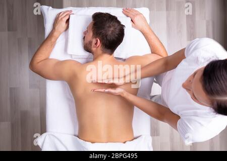 Close-up of a Young Man détendue Receiving Shoulder Massage Banque D'Images