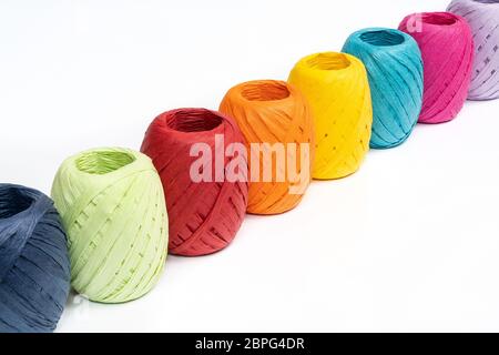 Quelques balles de raphia de couleur sur une surface blanche Banque D'Images