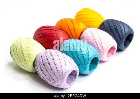 Quelques balles de raphia de couleur sur une surface blanche Banque D'Images