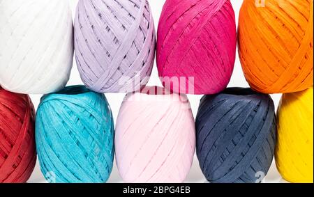 Quelques balles de raphia de couleur sur une surface blanche Banque D'Images