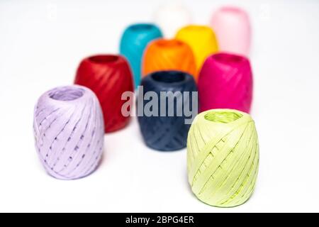 Quelques balles de raphia de couleur sur une surface blanche Banque D'Images