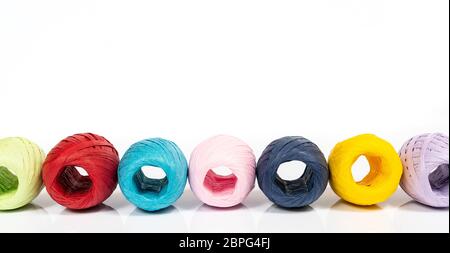 Quelques balles de raphia de couleur sur une surface blanche Banque D'Images