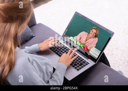 Close-up of a Girl la visioconférence avec Happy Female Teacher On Laptop Banque D'Images