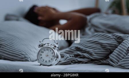 Femme afro-américaine souffrant d'insomnie couché au lit sans sommeil. Banque D'Images