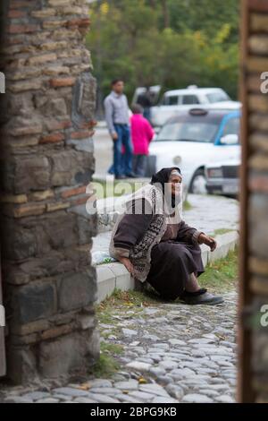 Une femme demande de l'argent aux touristes et aux visiteurs du Palais des Kans Shaki, en Azerbaïdjan Banque D'Images