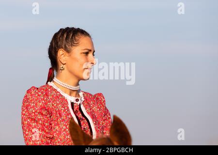 HORTOBAGY, HONGRIE, NOVEMBRE 04. 2018: Portrait de la femme hongroise csikos en costume traditionnel folklorique à cheval son cheval entraîné. Novembre 04. 2018, Ho Banque D'Images