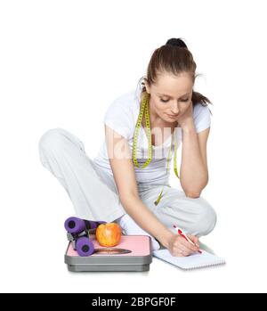 Jeune belle femme avec des écailles, pomme, haltères et ordinateur portable sur fond blanc. Concept de mode de vie sain. Banque D'Images