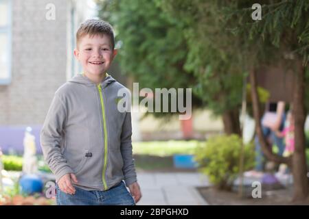 Biélorussie, ville de Goml, 26 avril 2019. Photosession dans la maternelle.Joyful garçon marche dans la rue. Joyeux enfant sourit sur le fond de Banque D'Images