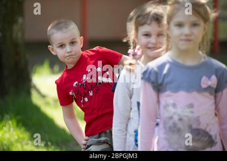 Biélorussie, ville de Gomil, 26 avril 2019. Jardin d'enfants dans la rue.UN garçon de jardin d'enfants sur une promenade d'été sur le fond des enfants flous Banque D'Images