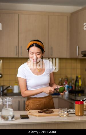 Femme faisant du toast au beurre d'arachide avocat pour un petit déjeuner sain à la maison Banque D'Images