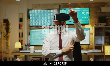 Trader boursier masculin utilisant la réalité virtuelle dans le bureau à domicile. Banque D'Images