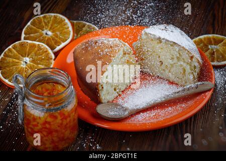 Tranches de gâteau dans une assiette sur une table en bois avec un pot d'orange confite Banque D'Images