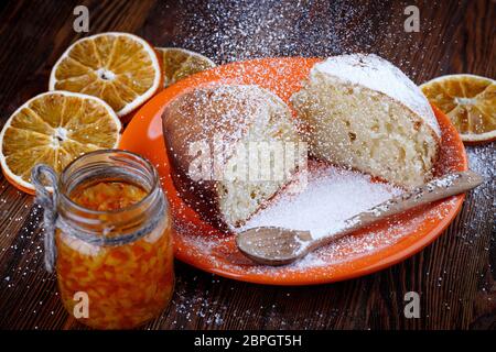 Tranches de gâteau dans une assiette sur une table en bois avec un pot d'orange confite Banque D'Images