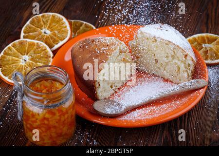 Tranches de gâteau dans une assiette sur une table en bois avec un pot d'orange confite Banque D'Images