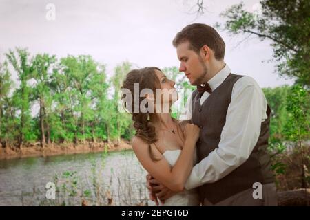 Mariée et le marié portrait sur le fond d'une montagne et de l'herbe. Banque D'Images