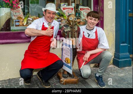 Clonakilty, West Cork, Irlande. 19 mai 2020. De nombreuses personnes portent des masques pendant la pandémie de Covid-19, et même des statues. Arthur la statue a été repéré portant un masque à gaz à l'extérieur de la boutique des bouchers de Scully à Clonakilty aujourd'hui. Arthur est photographié avec Craig et Dave Scully, propriétaires de la boucherie. Crédit : AG News/Alay Live News Banque D'Images