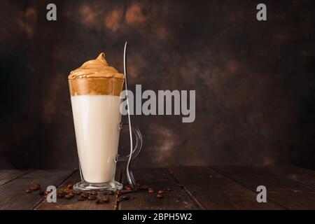 Un long verre avec un café fouetté très tendance de Dalgona sur fond sombre Banque D'Images