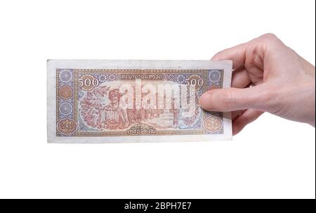 Main femelle tenant une monnaie de 500 KIP 1988 billets isolée sur fond blanc. Dénomination de 500 Kips. Banque D'Images