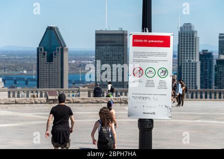 Montréal, CA - 18 mai 2020 : affiche montrant les lignes directrices françaises Covid-19 et les gratte-ciel de Montréal au loin. Banque D'Images