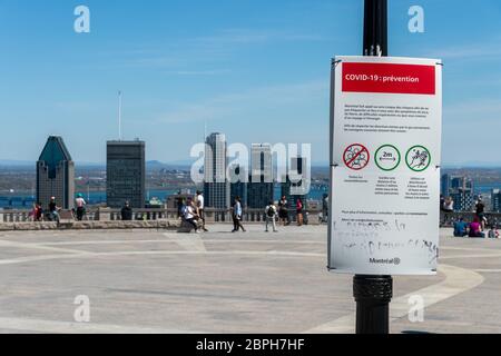 Montréal, CA - 18 mai 2020 : affiche montrant les lignes directrices françaises Covid-19 et les gratte-ciel de Montréal au loin. Banque D'Images