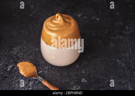 Un verre de café fouetté crémeux et mousseux Dalgona sur fond noir Banque D'Images