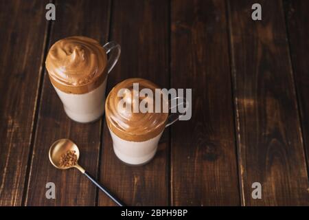 Vue de dessus de deux verres avec le célèbre café Dalgona sur table en bois sombre Banque D'Images