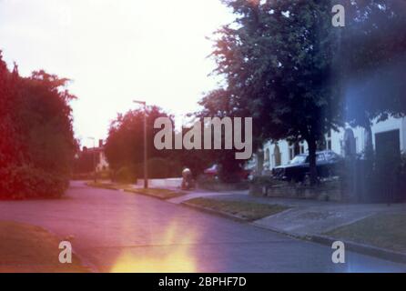 Une maman qui pousse ses enfants sur la route dans leur kart maison, dans la banlieue, Hatch End Park Estate, Milne Feild, Hatch End, Middlesex, Royaume-Uni Banque D'Images