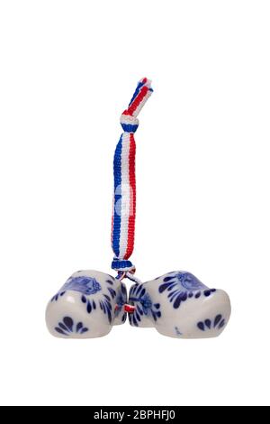 Sabots en bois Holland. Une paire de chaussures traditionnelles en porcelaine hollandaise avec un drapeau à ruban isolé sur un fond blanc. Souvenir d'Amsterdam. Banque D'Images