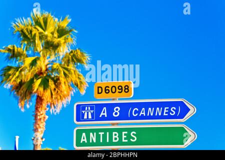 Cote d Azur panneau routier à Antibes et Cannes, Palm et fond de ciel bleu azur, Banque D'Images