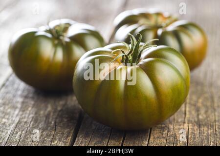 Brandywine noire tomates sur vieille table en bois. Banque D'Images