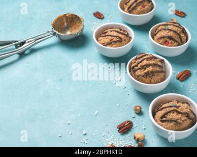 Coffre-à-manger de monster cookie dough en petite partie bol, cuillère à crème glacée et les écrous sur fond bleu. Des idées et recettes pour les enfants et les tout-petits repas. Banque D'Images