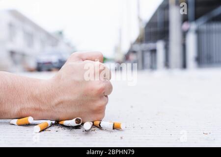 Arrêtez de fumer. Gros plan de la cigarette masculine rompant la main avec son poing dans la ville natale. Journée du tabac. Cigarette. Banque D'Images