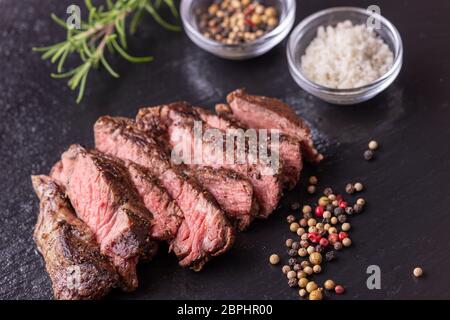 Tranches d'un steak grillé sur ardoise Banque D'Images