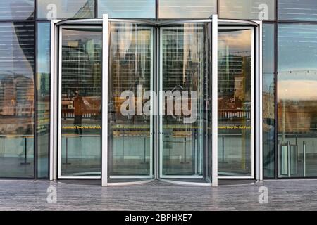 La porte tournante automatique à l'immeuble de bureaux en verre Banque D'Images