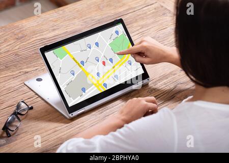 Close-up of a Woman's Hand en utilisant la carte de navigation GPS sur ordinateur portable numérique Banque D'Images