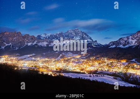Cortina Ampezzo station de ski ville la nuit. Montagnes couvertes de neige en arrière-plan. Province de Belluno, Italie Banque D'Images